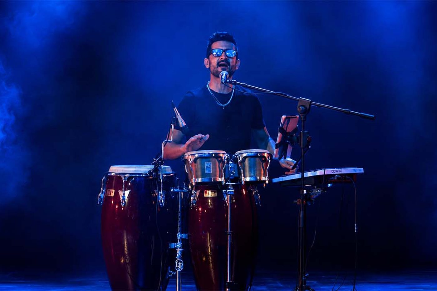 Jespo alle congas sul palco, nella luce blu